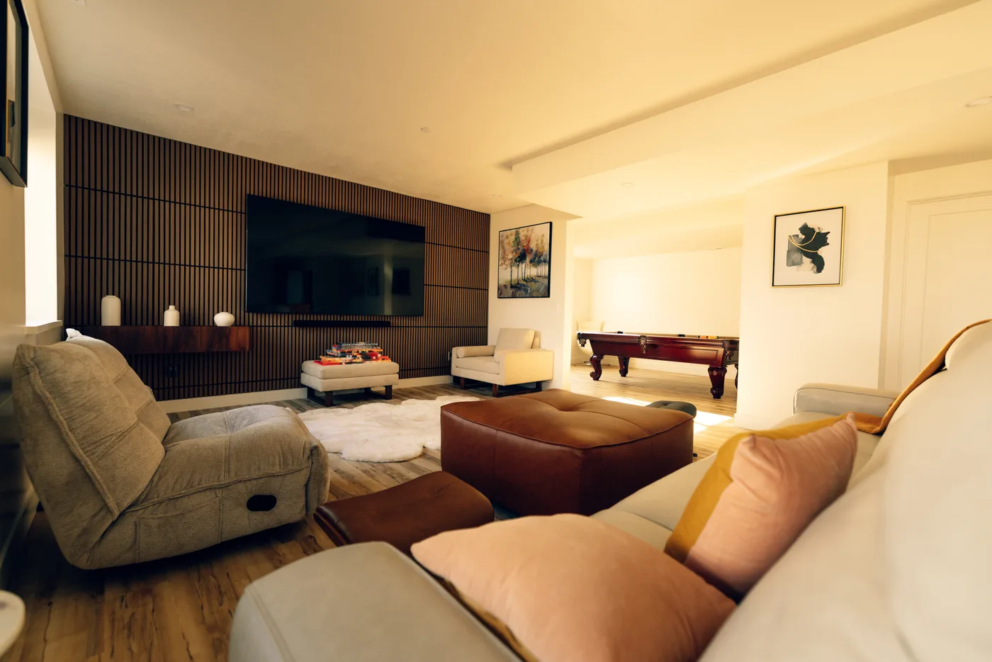 Finished basement entertainment room with TV wall and pool table